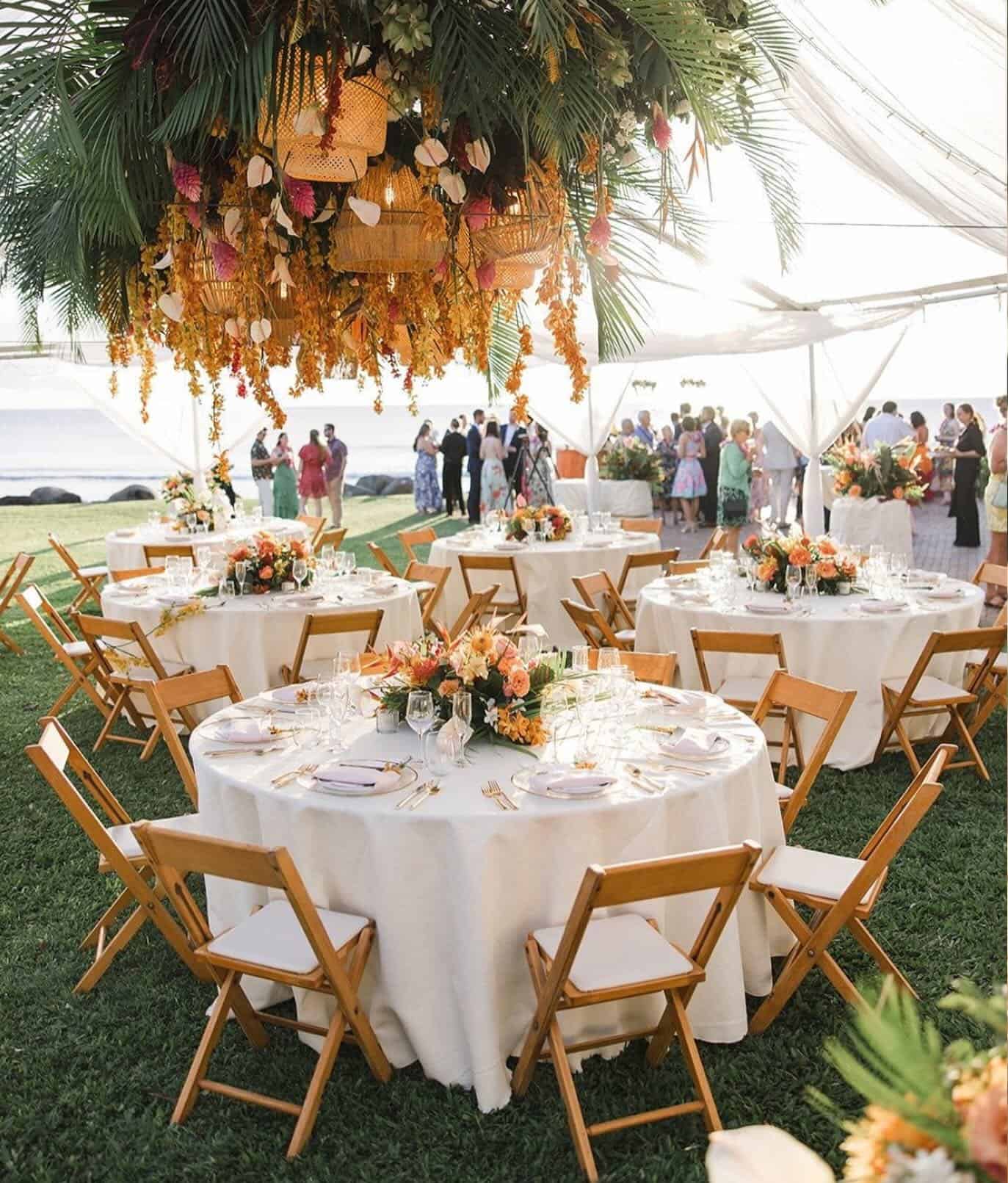 Beautiful outdoor wedding reception with floral decor and round tables.