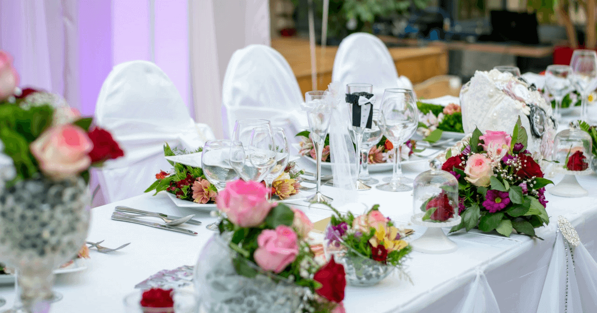 Beautifully decorated wedding reception table with floral arrangements and fine glassware.
