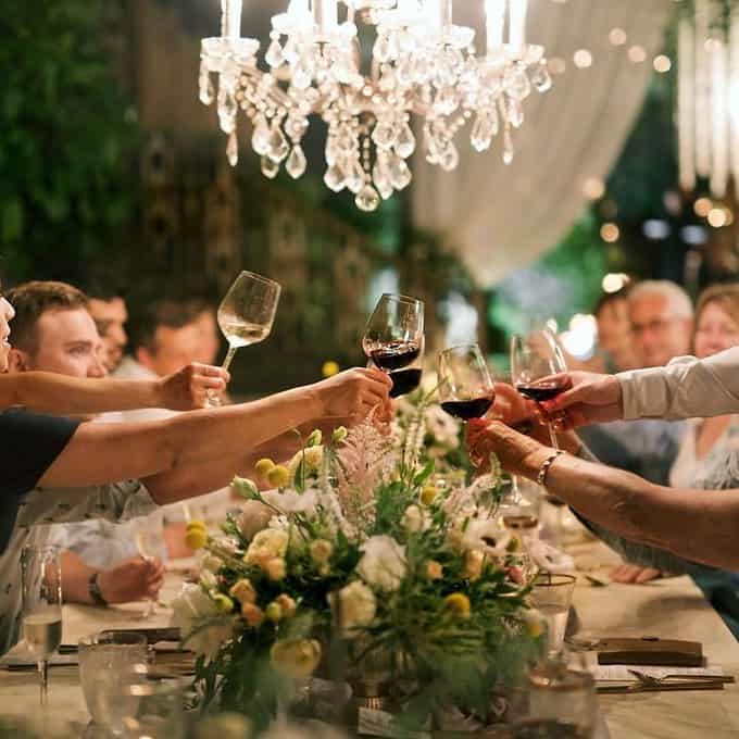 Guests clinking wine glasses at a formal dinner event.