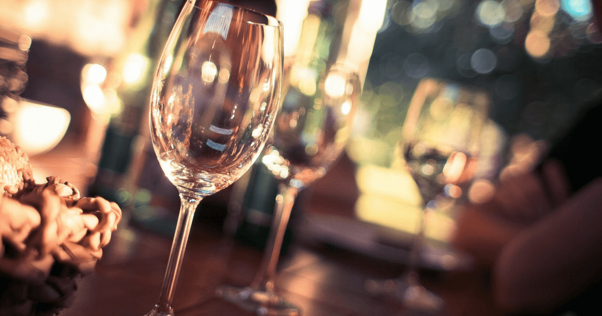 Close-up of empty wine glasses on a table at outdoor event.